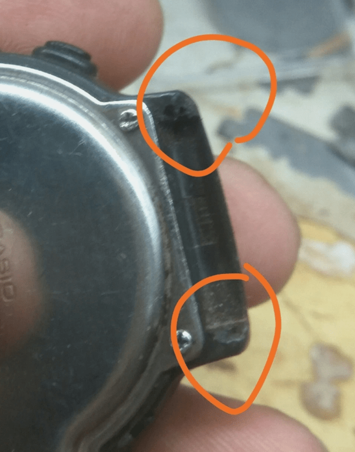 Close-up of Casio CPW-310 watch case showing broken strap lug near screw mounts.