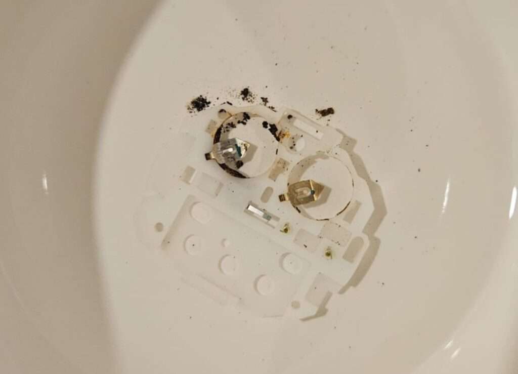 Casio CPW-310 plastic module holder being cleaned in isopropyl alcohol.