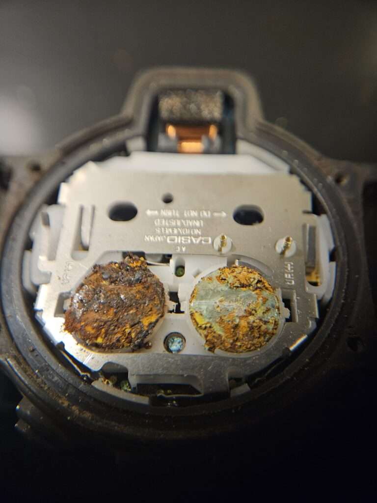 Corroded battery terminals inside Casio CPW-310 watch mechanism.