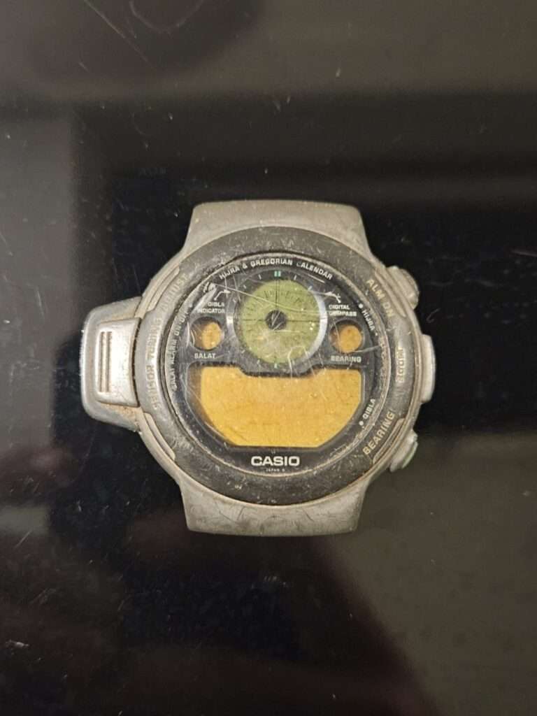 Old worn Casio CPW-310 wristwatch with damaged display and casing.