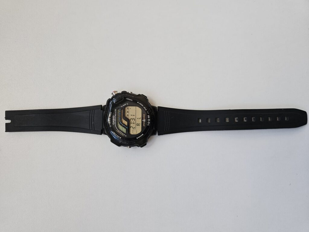 Vintage Casio STR-1000 watch with original black strap laid flat.