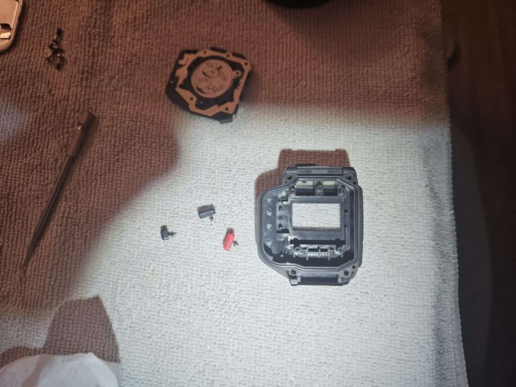 Casio JG-100 internal frame exposed with removed module and components.