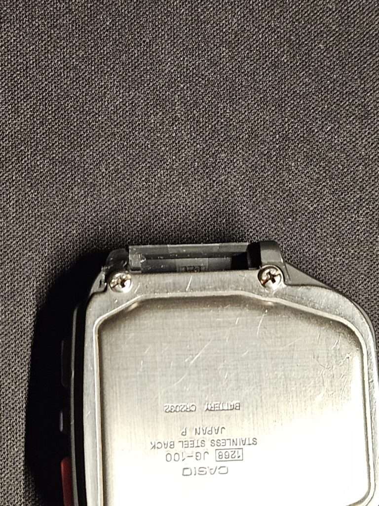 Rear view of the Casio JG-100 with stainless steel case back and strap hinge.