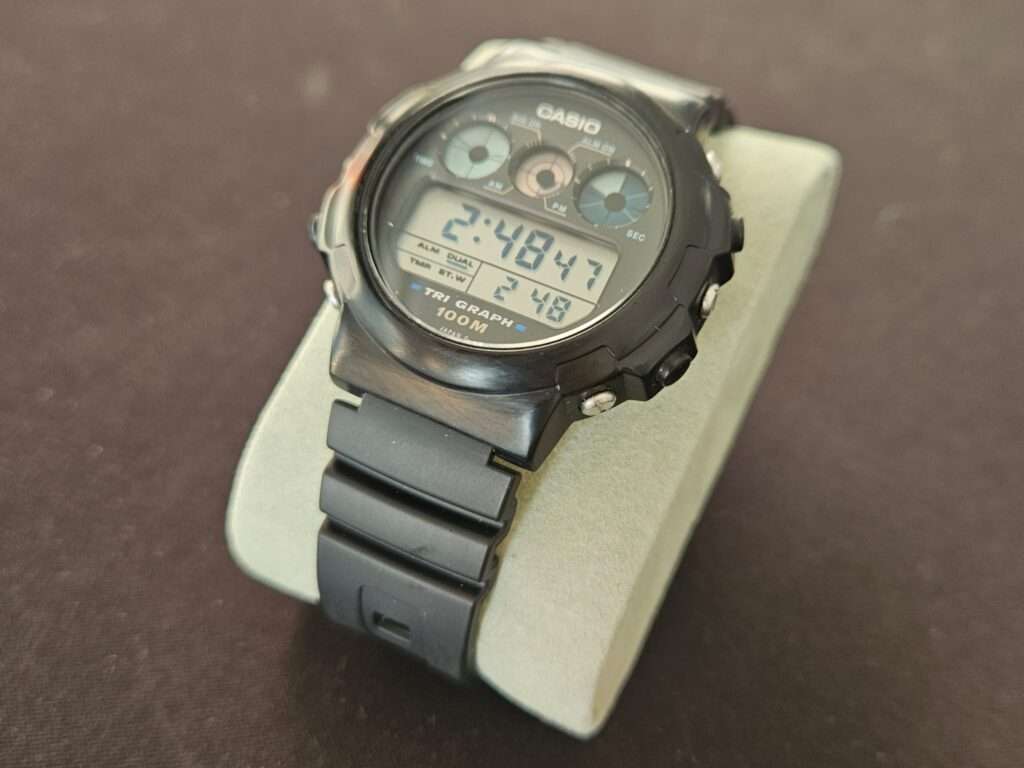 Casio TGW-10 Tri Graph digital watch on display stand viewed at an angle