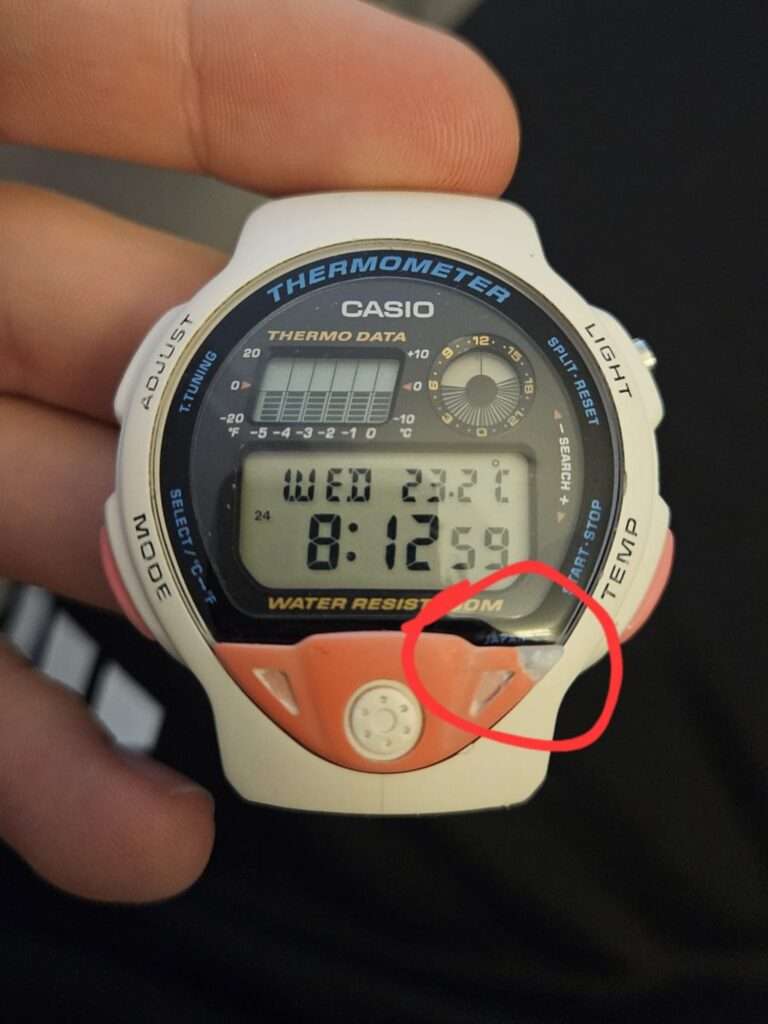 Restored Casio TS-200 white case held in hand showing working dial at 8:12, temperature 23.2°C, with red annotation circle