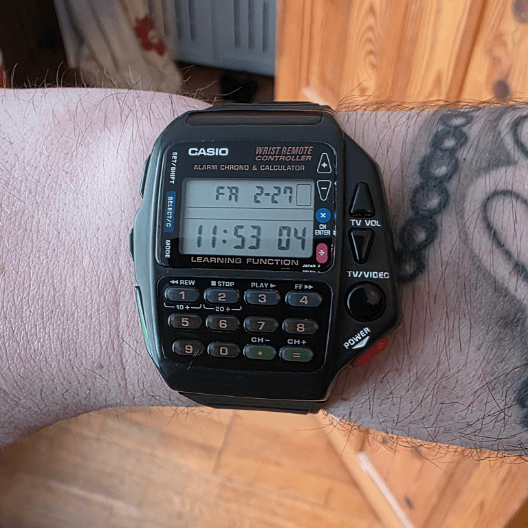 Restored Casio CMD-40 Wrist Remote Controller worn on tattooed wrist, showing alarm chrono calculator display