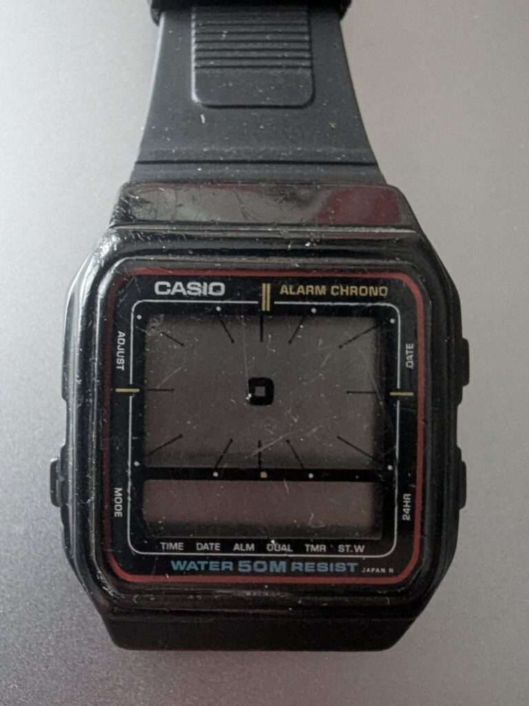 Casio AE-11W Alarm Chrono digital watch with heavily scratched crystal and worn resin strap before restoration