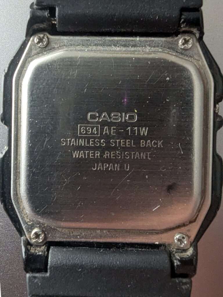 Casio AE-11W module 694 stainless steel case back with scratches before restoration, marked Water Resistant Japan U