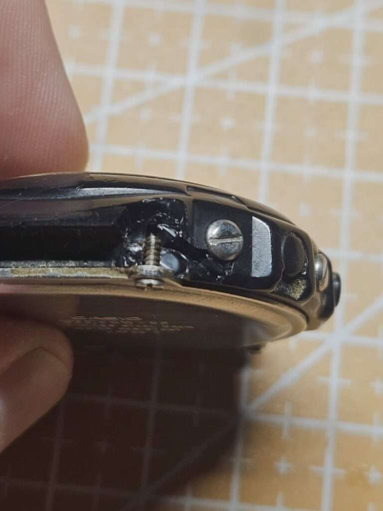 Casio CGW-50 Cosmo Phase broken lug with cracked resin case and exposed screws, closeup pre-restoration