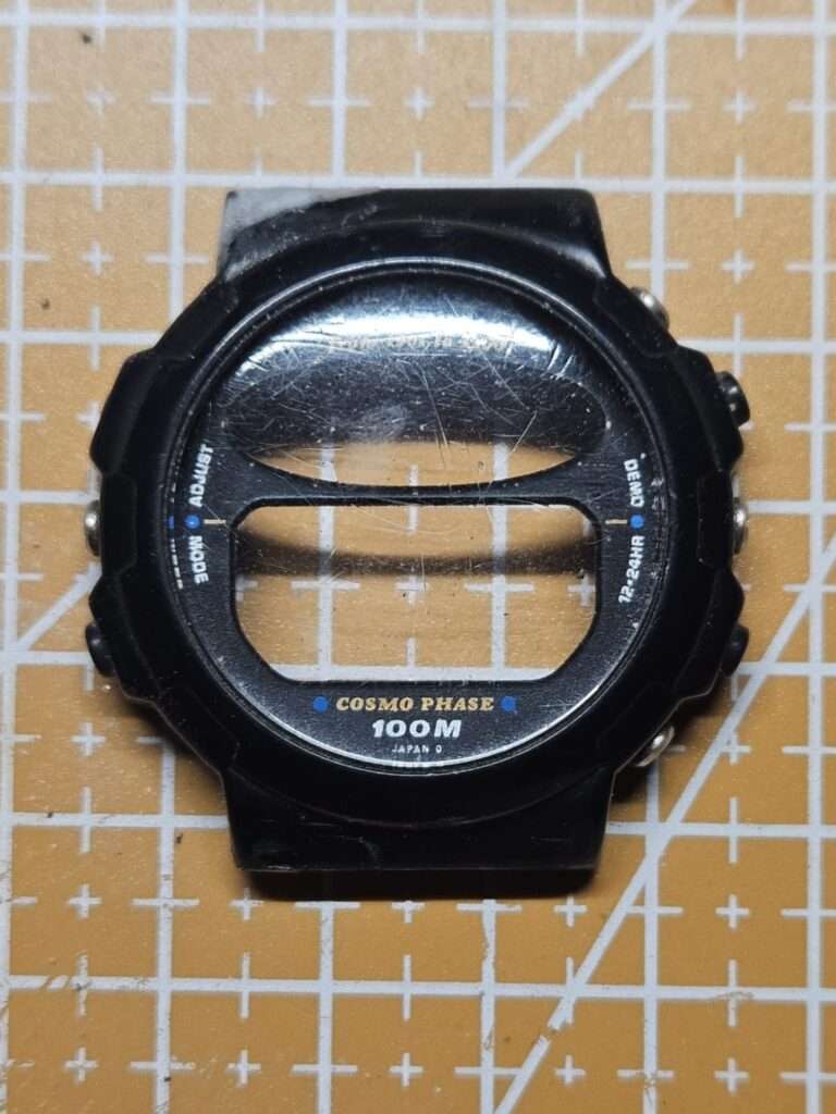 Casio CGW-50 Cosmo Phase front bezel with scratched acrylic crystal, Cosmo Phase 100M dial, lugs mid-repair