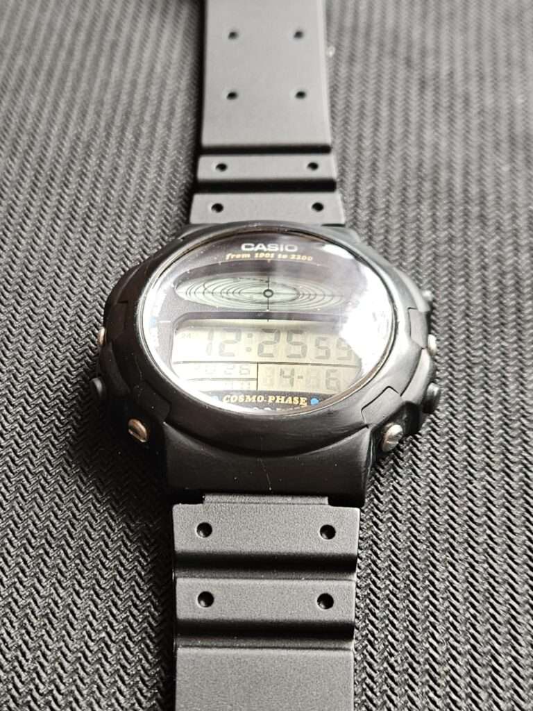 Casio CGW-50 Cosmo Phase restored watch laid flat at slight angle on dark surface with black strap
