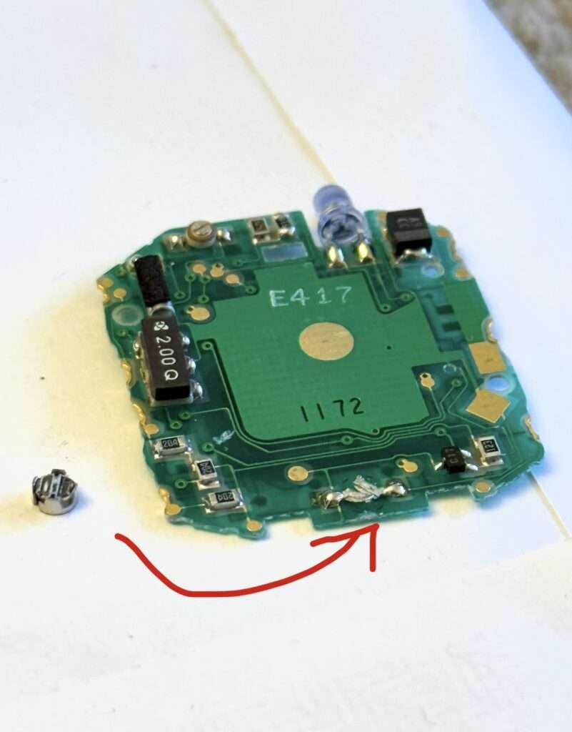 Casio CMD-30 PCB circuit board with detached coil component highlighted by red arrow, placed next to the board