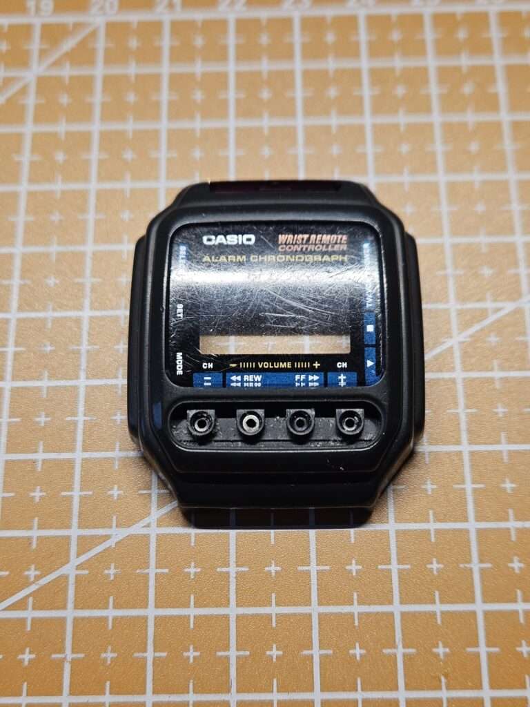 Casio CMD-30 black case with heavily scratched mineral crystal and exposed IR emitter port before restoration