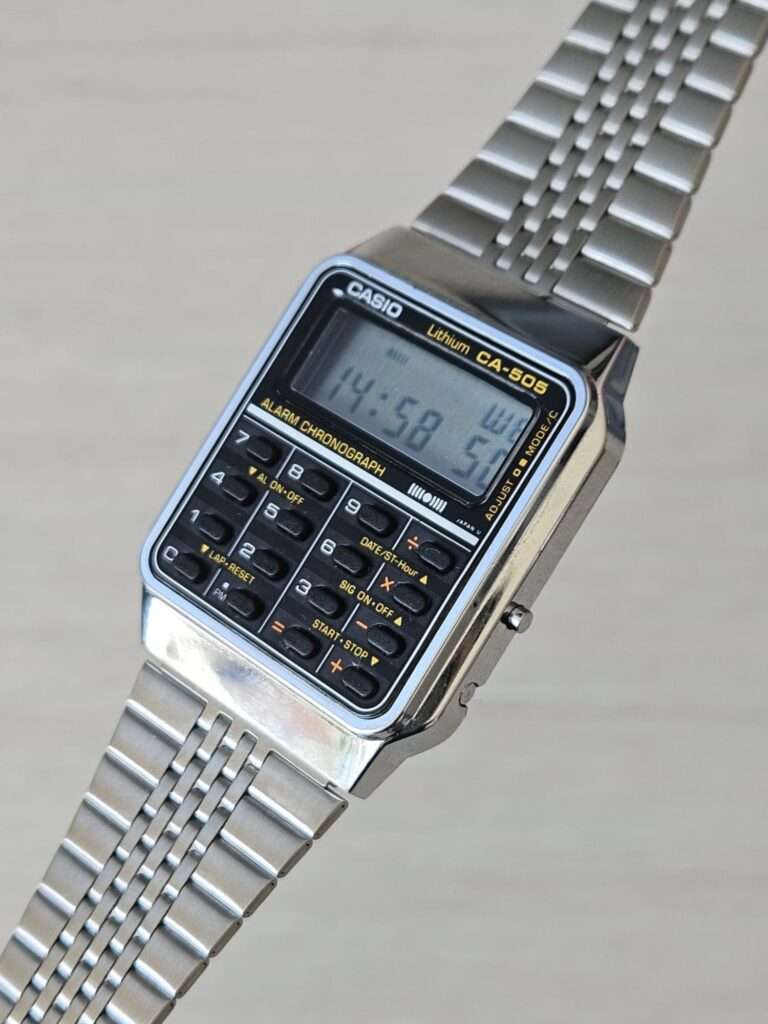 Casio CA-505 vintage calculator watch after restoration, diagonal view with LCD showing 14:58 on stainless bracelet