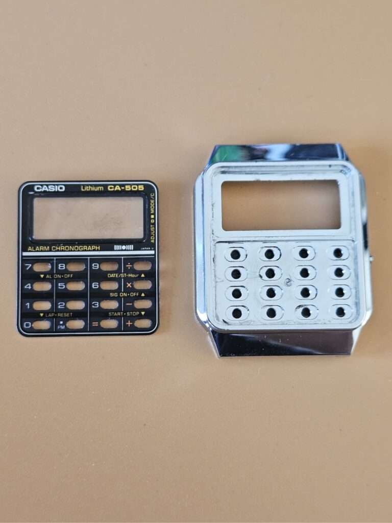 Casio CA-505 fully disassembled showing case shell, keypad panel, rubber membrane and display gaskets