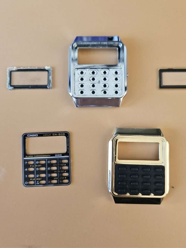 Casio CA-505 case and CA-505 keypad panel disassembled side by side for keypad transplant restoration