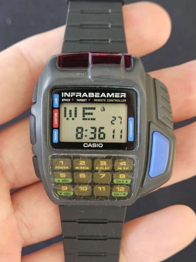 Casio JG-10 Infrabeamer watch held in hand displaying WE 27 8:36 11 on clear LCD after restoration