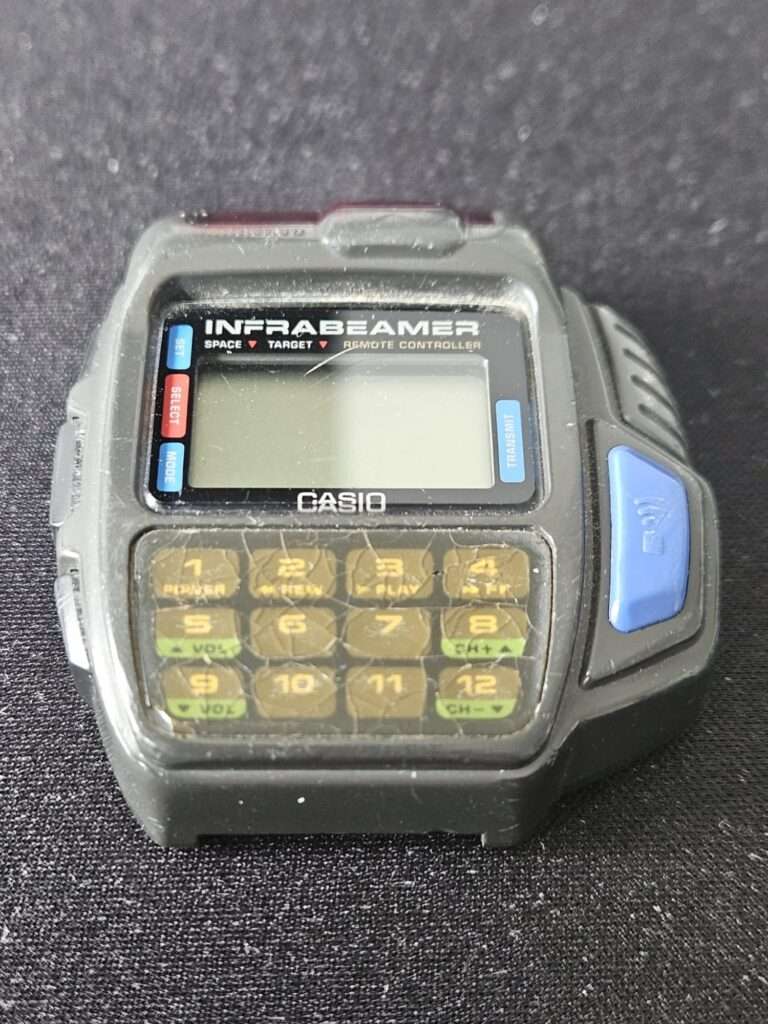 Casio JG-10 Infrabeamer remote controller watch front view showing LCD display and 12-button keypad before restoration