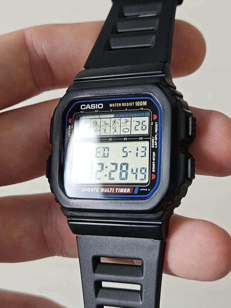 Casio STW-100 Sports Multi Timer after restoration, held in hand showing fully working LCD with date WED 5-13 and time 12:28