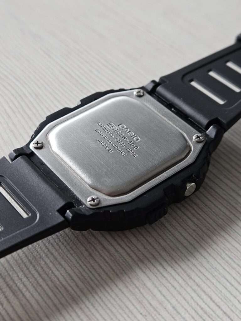 Casio STW-100 stainless steel case back after restoration, four screws, Japan M engraving on textured surface