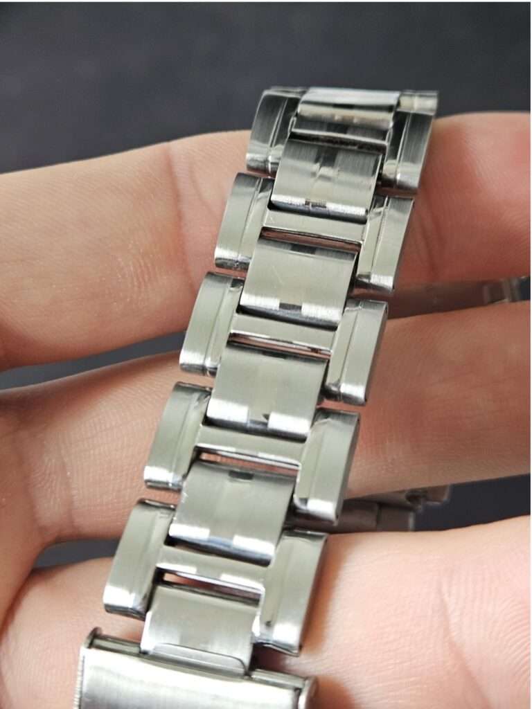 Polished Casio CGW-500 Cosmo Phase stainless steel bracelet links held in hand after restoration