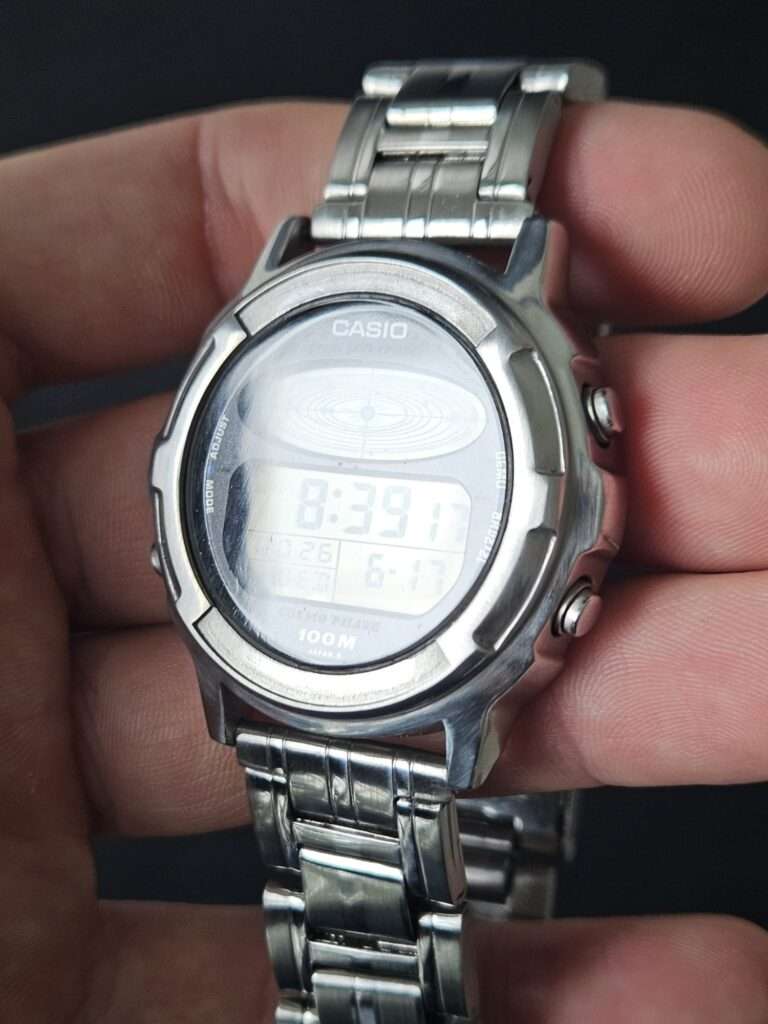Restored Casio CGW-500 Cosmo Phase watch in hand with bright reflection across the freshly polished crystal