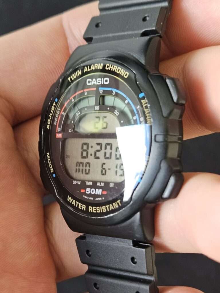 Restored Casio W-95 Twin Alarm Chrono digital watch at an angle with reflective crystal and lit display