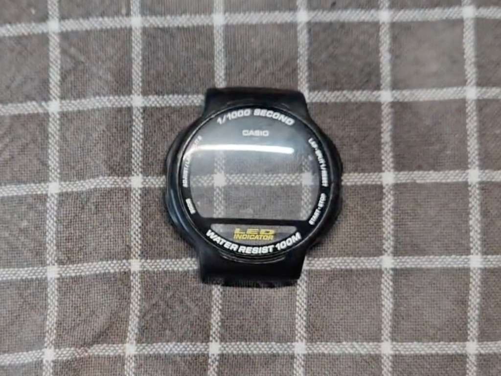 Casio watch crystal after final high-grit sanding stage, showing a clear smooth surface