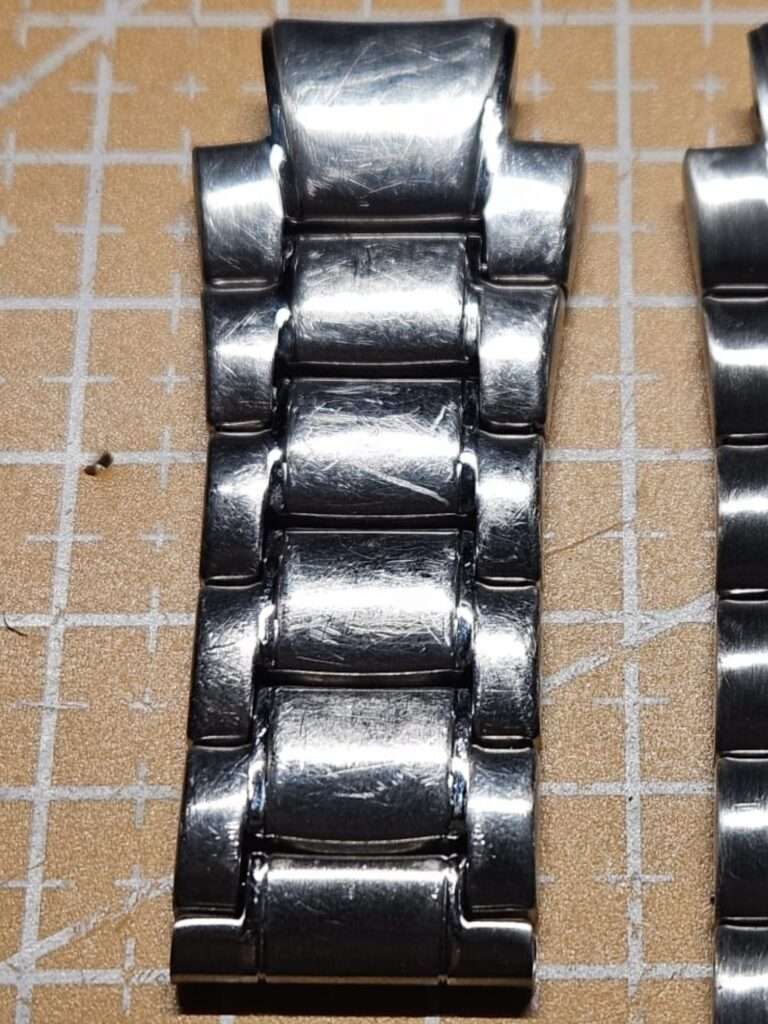 Fossil Big Tic JR8096 stainless steel bracelet top view, curved links with heavy surface scratches, pre-restoration