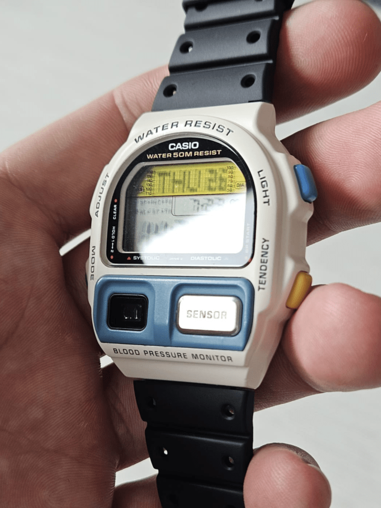 Casio BP-100 white restored watch held in hand showing blood pressure display