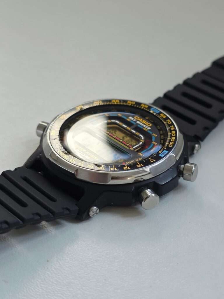 Casio DW-401 Sky Walker on white surface, angled view of polished crystal and steel bezel