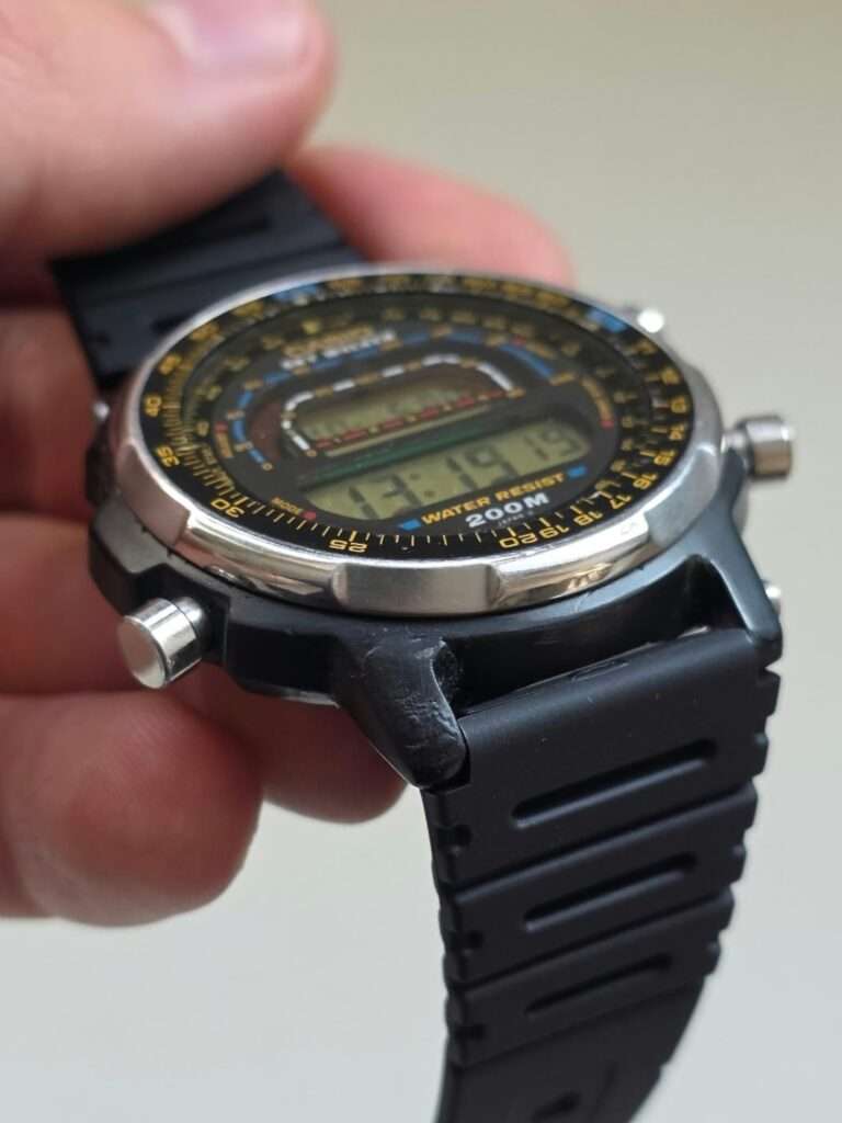 Casio DW-401 Sky Walker held in hand showing repaired resin lug, steel bezel and black rubber strap