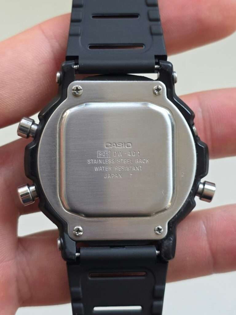 Clean Casio DW-401 stainless steel case back with 905 module engraving on black resin strap