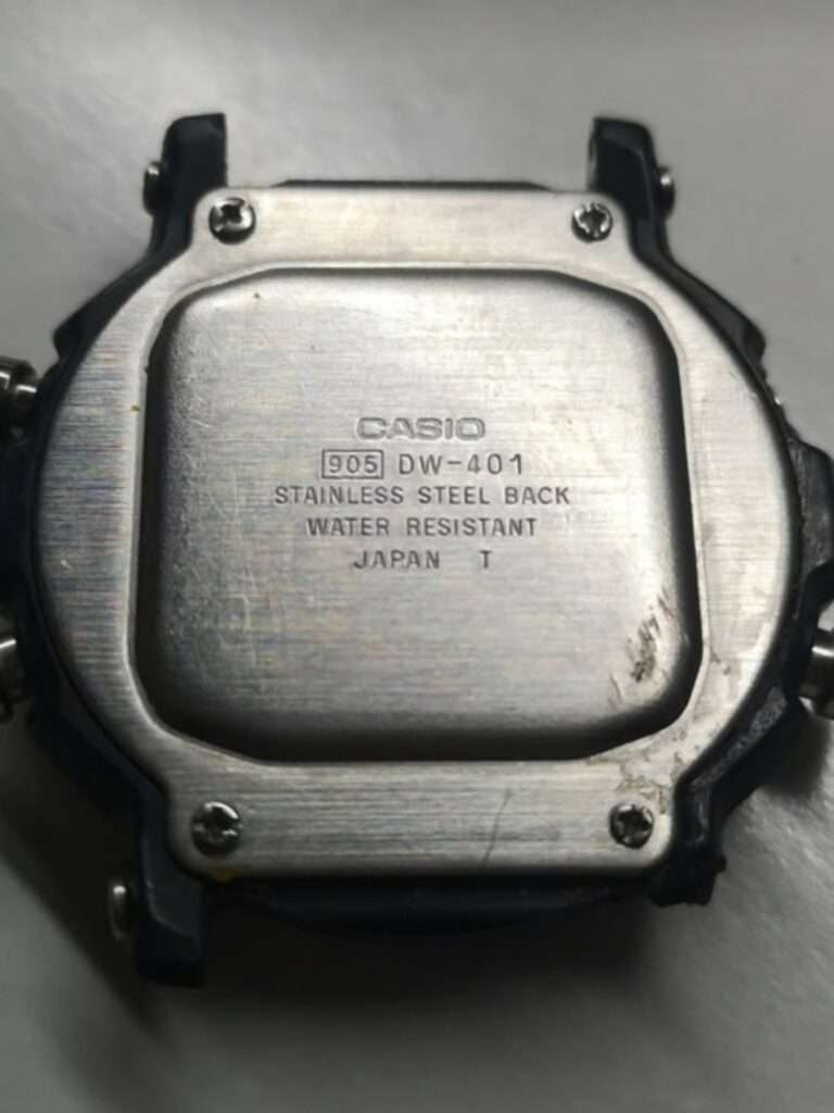 Casio DW-401 stainless steel case back with 905 module engraving, scratches and dirt before restoration